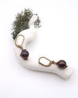 Bird’s eye view of garnet drop earrings laying flat on a display, showing detailed wire wrapping and gemstone color.