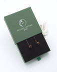 Garnet drop earrings presented in a branded gift box, ready for gifting, with antique bronze copper wire wrapping.