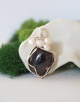 Detailed front view of silver wire wrapped garnet and freshwater pearl pendant, unique artisan necklace