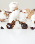Two garnet pendants and two pairs of garnet stud earrings showing natural variation in size, shape, and color of garnet stones