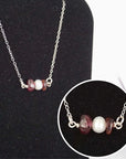 Close-up of raw garnet stones and freshwater pearl bar on 925 sterling silver necklace