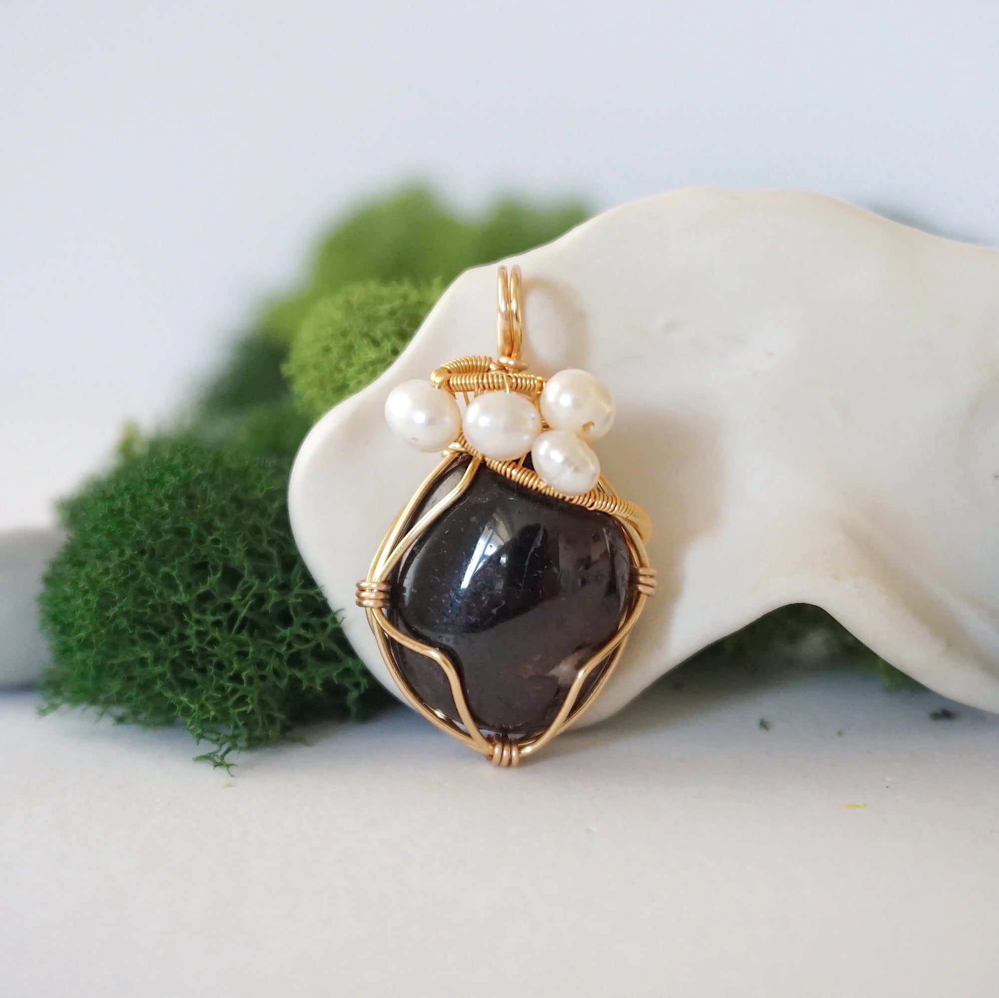 Detailed front angle of garnet and freshwater pearl pendant, gold wire wrapped, handcrafted gemstone jewelry