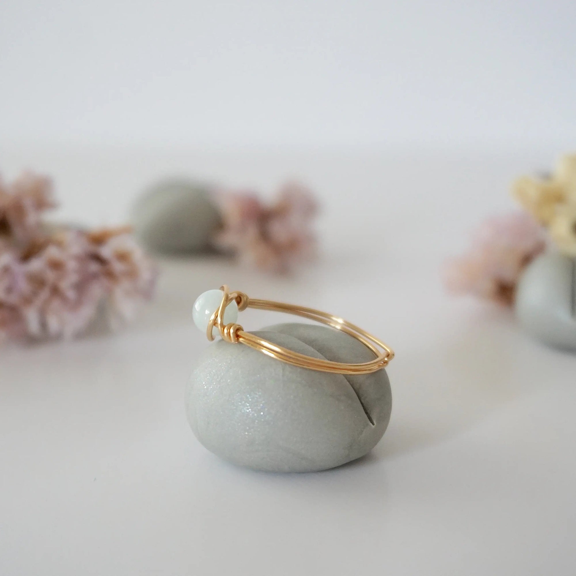 Side angle of gold aquamarine ring, artisan wire wrapped, minimalist design