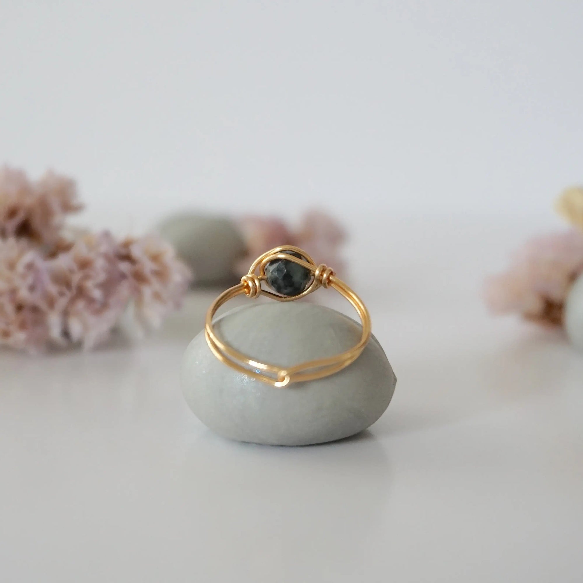 Back view of minimalist gold emerald ring highlighting handcrafted wire wrapping detail.