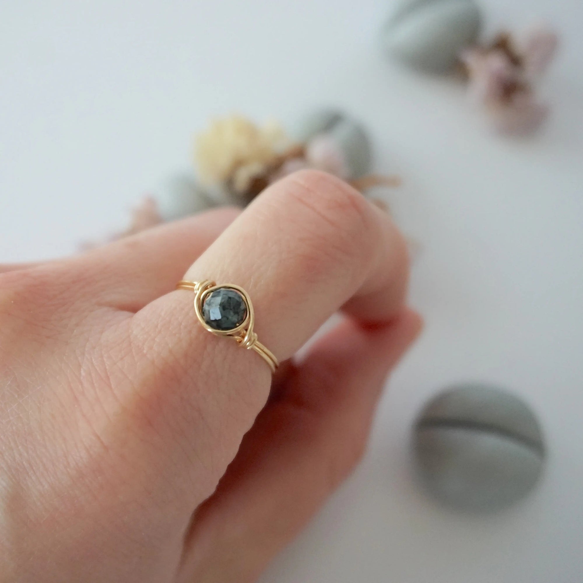 Minimalist gold emerald ring on a model's hand by Designs by Nature Gems, handcrafted May birthstone ring for women.