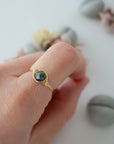 Minimalist gold emerald ring on a model's hand by Designs by Nature Gems, handcrafted May birthstone ring for women.