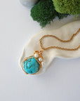 Gold turquoise pearl necklace with raw crystal and freshwater pearl on brass chain, full length flat lay view