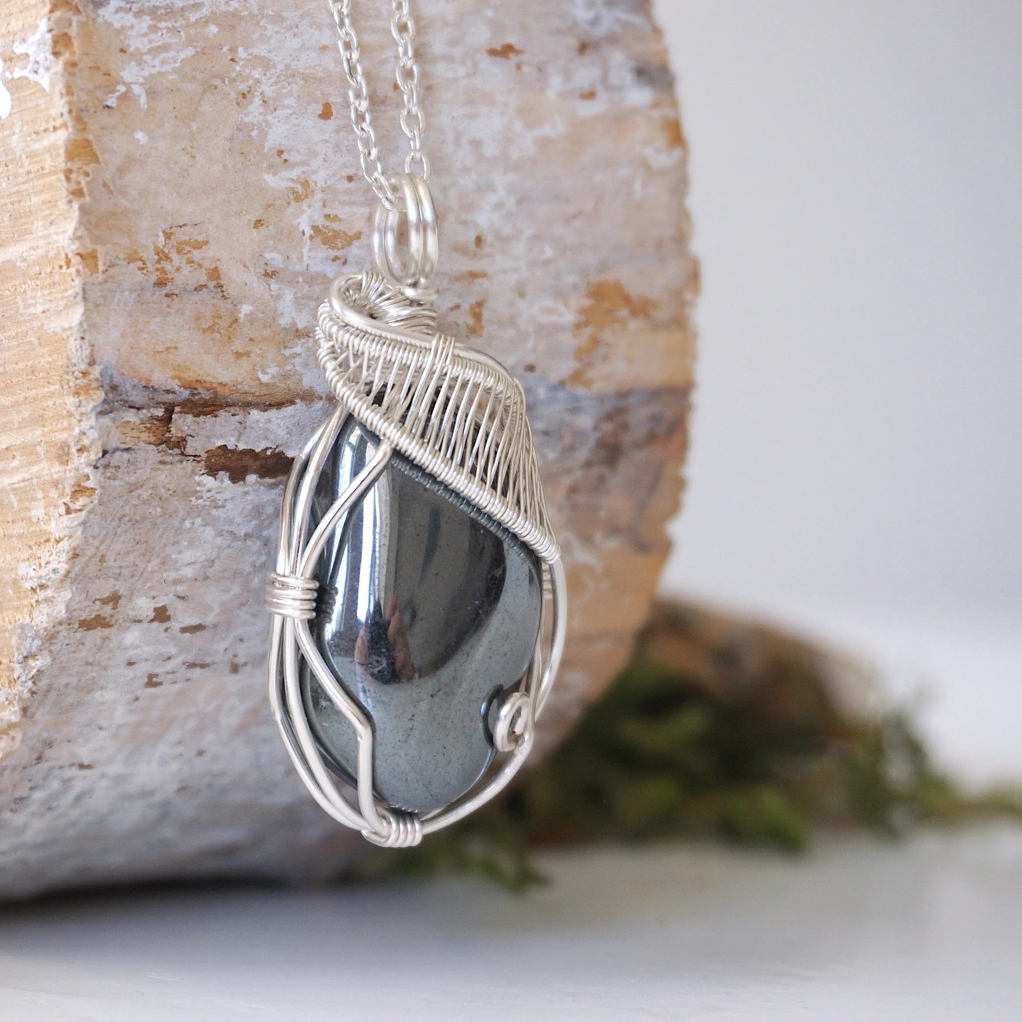 Right angle close-up of wire wrapped hematite necklace showing artisan soft silver over copper wrapping details