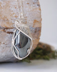 Right angle close-up of wire wrapped hematite necklace showing artisan soft silver over copper wrapping details