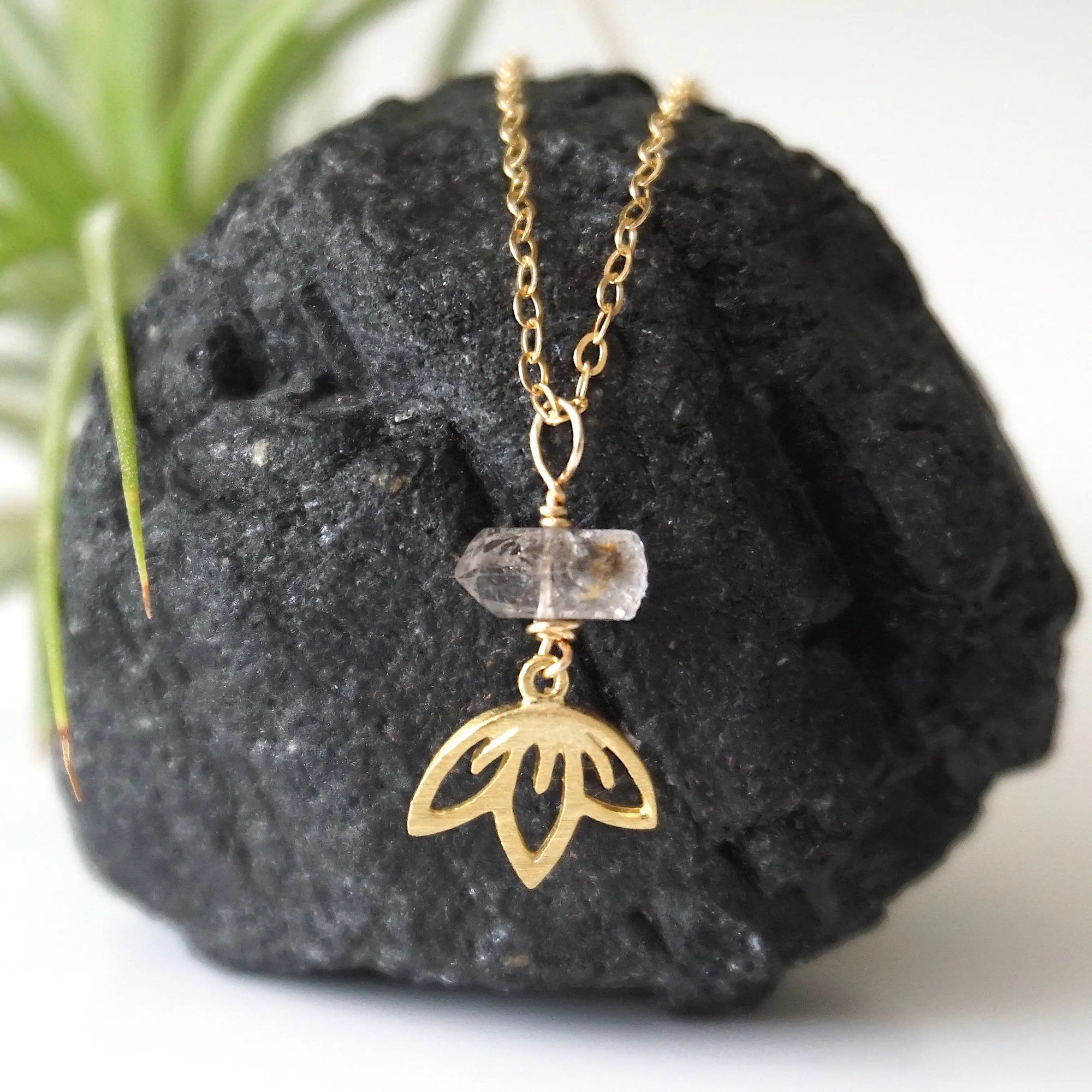 Detailed view of Herkimer diamond and lotus necklace in gold vermeil with natural raw crystal and symbolic lotus charm.