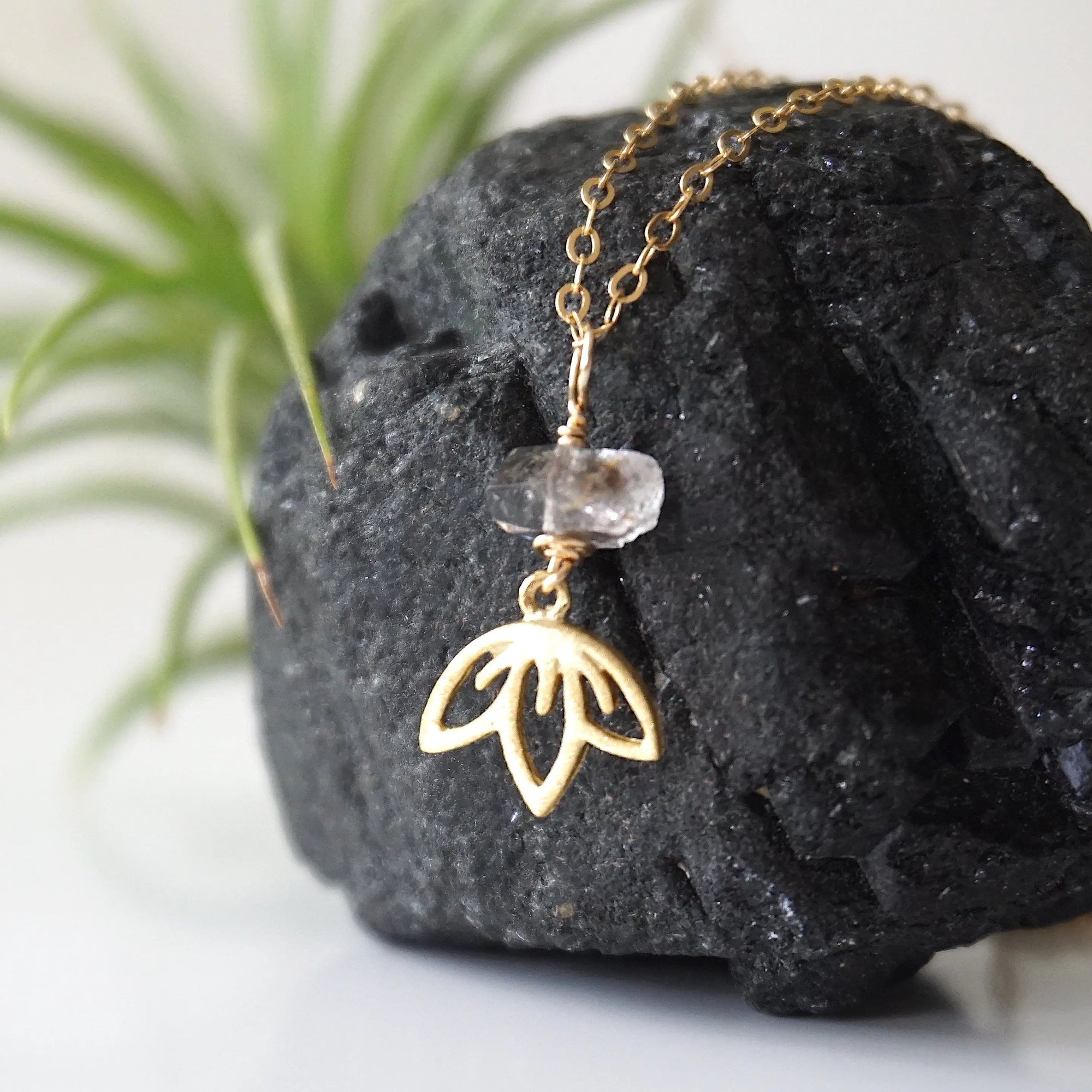 Left angle detail of Herkimer diamond and lotus necklace showing artisan design in gold vermeil.