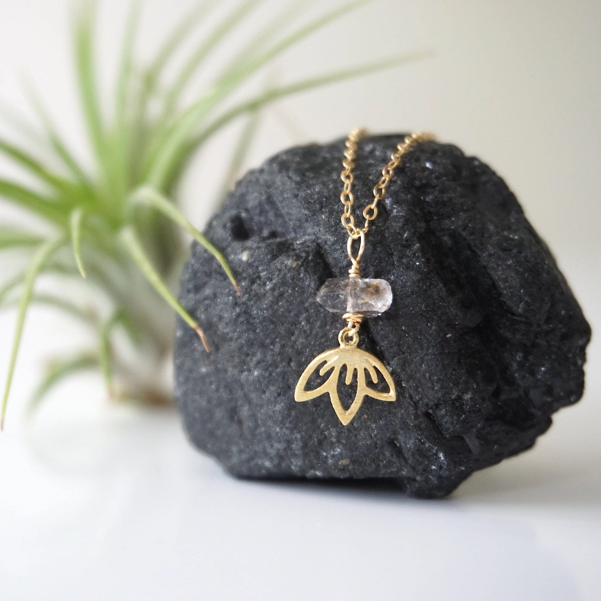 Zoomed out view of Herkimer diamond and lotus necklace in gold vermeil with minimalist artisan styling.