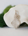Back angle detail of raw Herkimer diamond pendant with intricate artisan wire wrapping in soft silver copper.