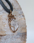 Right angle view of raw Herkimer diamond pendant for men showing detailed artisan wire wrapping in antique bronze copper.