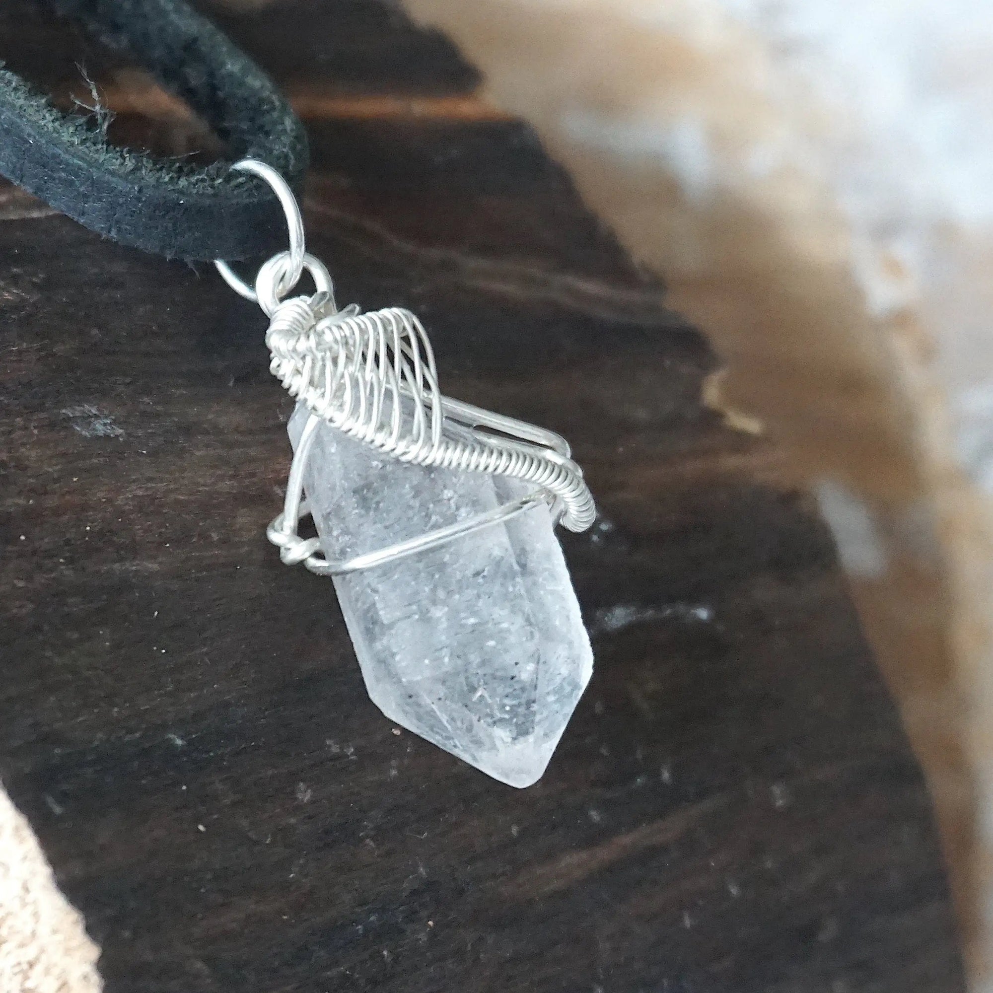 Right angle view of raw Herkimer diamond pendant for men showing detailed artisan wire wrapping in 925 sterling silver.