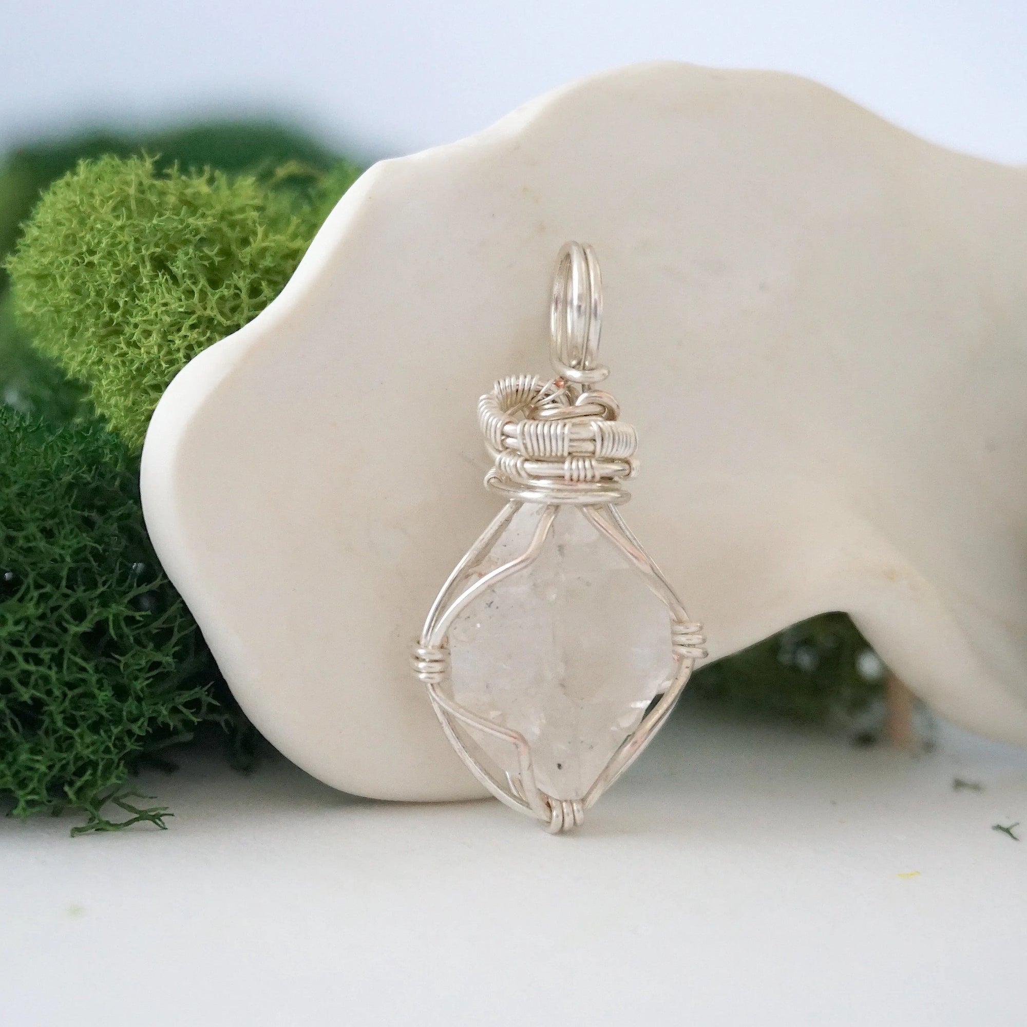 Right angle view of raw Herkimer diamond pendant showing detailed artisan wire wrapping in soft silver copper.
