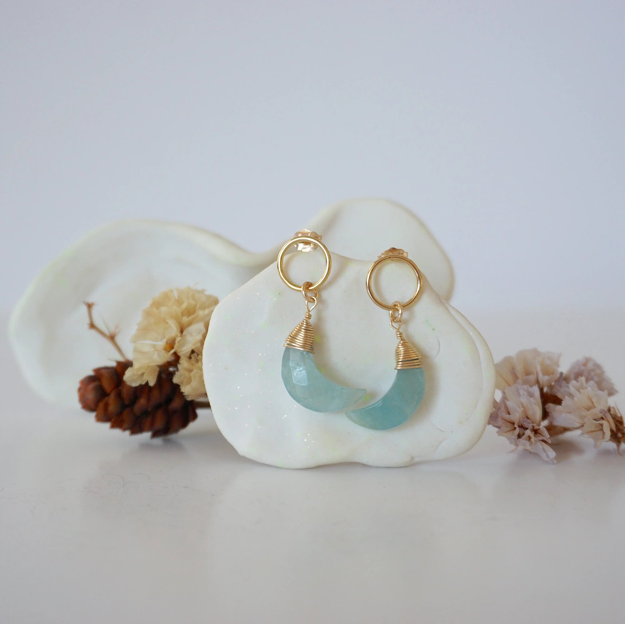Front angle look at Lux Aquamarine Moon Open Circle Stud Earrings on jewelry display, faceted natural aquamarine, gold filled, handmade.