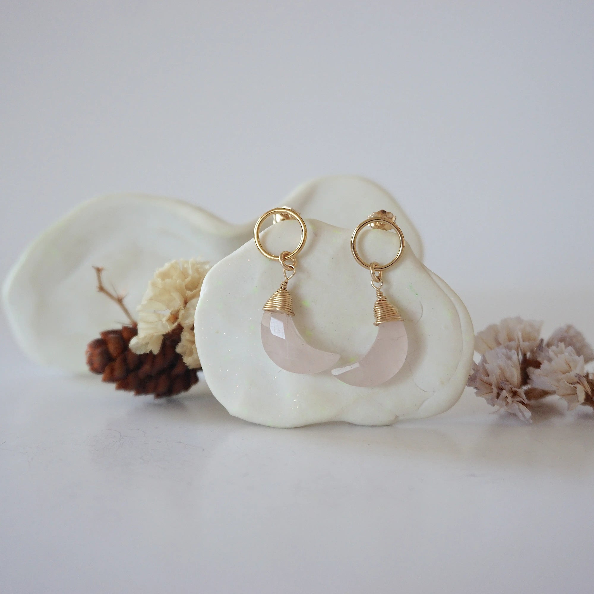 Front angle look at Lux Rose Quartz Moon Open Circle Stud Earrings on jewelry display, faceted natural rose quartz, gold filled, handmade.