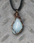 Men's aquamarine necklace with genuine polished aquamarine pendant, detailed front view, artisan wire wrapped in antique bronze copper, flat black leather cord, Designs by Nature Gems