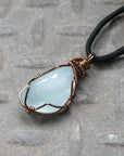 Left side angle of men's aquamarine necklace, showing artisan wire wrapping and polished aquamarine, antique bronze finish