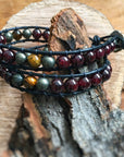 Angled view of a men’s leather wrap beaded bracelet with garnet as the dominant stone, accented with tiger’s eye and pyrite