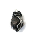 Side view of a men’s wire wrapped garnet pendant showing the mixed tin plated and black copper wire wrapping