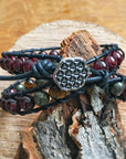 Back view of a men’s leather wrap beaded bracelet showing the Flower of Life button closure and handcrafted leather detailing