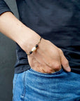Men’s pearl leather bracelet with lava stone accents shown worn on a model’s wrist