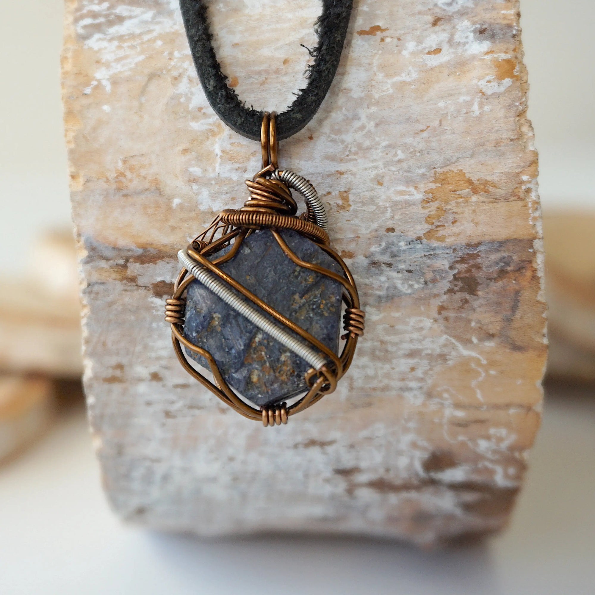 Back view of men's raw sapphire pendant showing the detail of antique bronze and dark silver wire-wrapping — one-of-a-kind artisan crystal jewelry