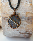 Back view of men's raw sapphire pendant showing the detail of antique bronze and dark silver wire-wrapping — one-of-a-kind artisan crystal jewelry