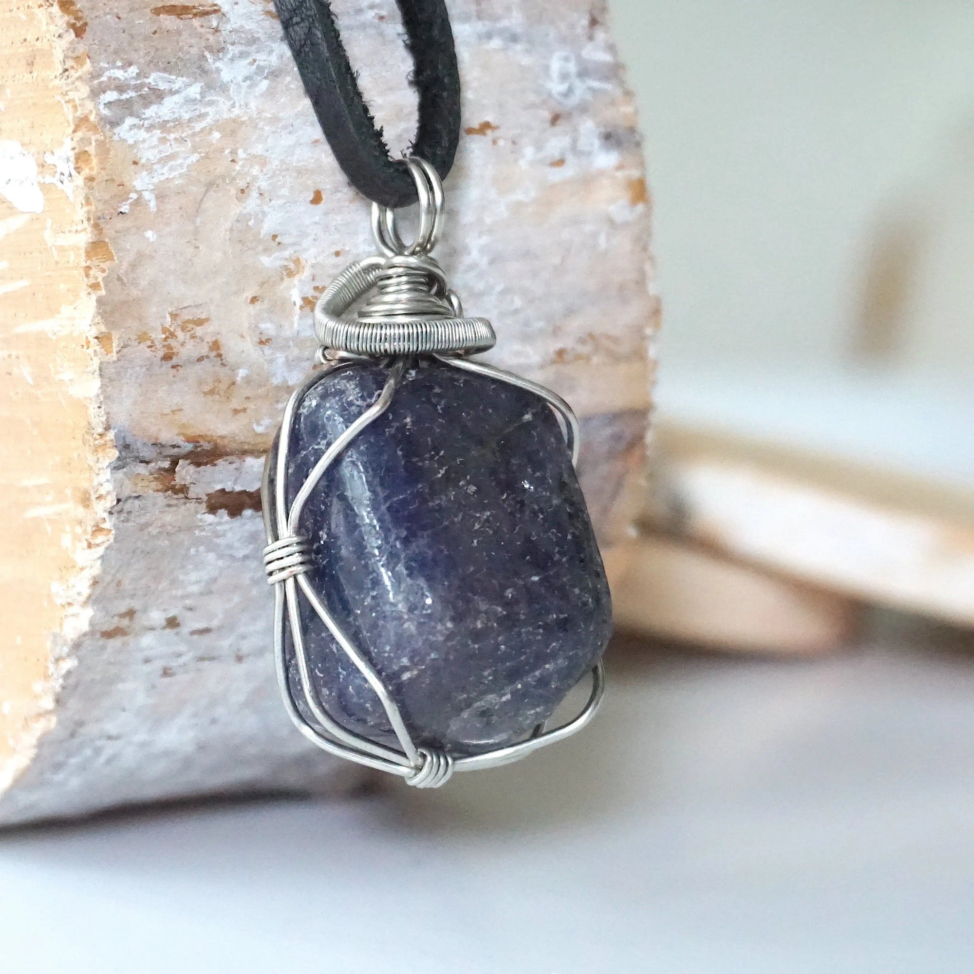 Right-angle detail of men's sapphire pendant showing artisan wire-wrapping in dark silver — handcrafted crystal necklace by Designs by Nature Gems