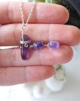 Amethyst necklace and stud earrings shown in hand for size reference, minimalist February birthstone jewelry set in silver