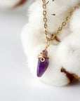 Left side angle of minimalist amethyst necklace for women, gold plated copper wire wrapped raw amethyst pendant