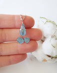 Minimalist aquamarine jewelry set with necklace and stud earrings in a hand for size reference, genuine polished aquamarine, Designs by Nature Gems