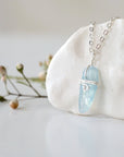 Left side angle of minimalist aquamarine necklace, polished aquamarine pendant, soft silver wire wrapping