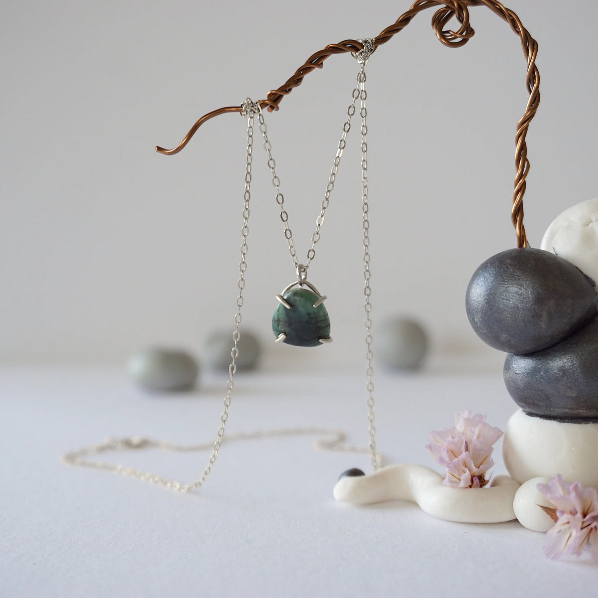 Zoomed out front view of minimalist emerald necklace in 925 sterling silver with natural emerald pendant.