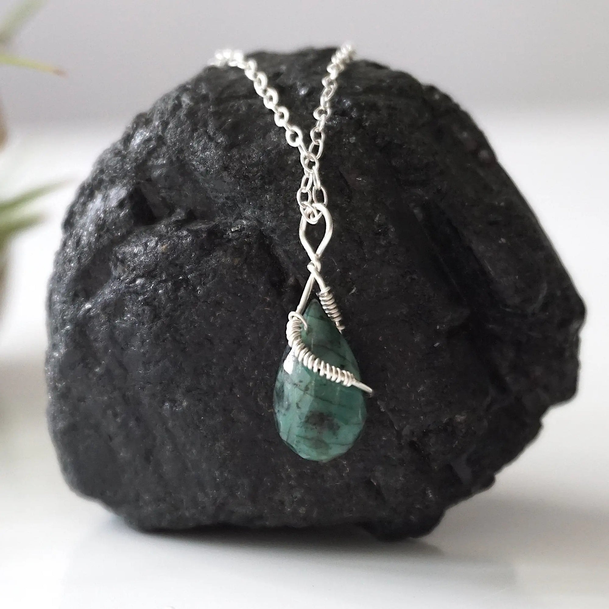Back angle detail of minimalist emerald pendant necklace for women with natural faceted emerald and sterling silver craftsmanship