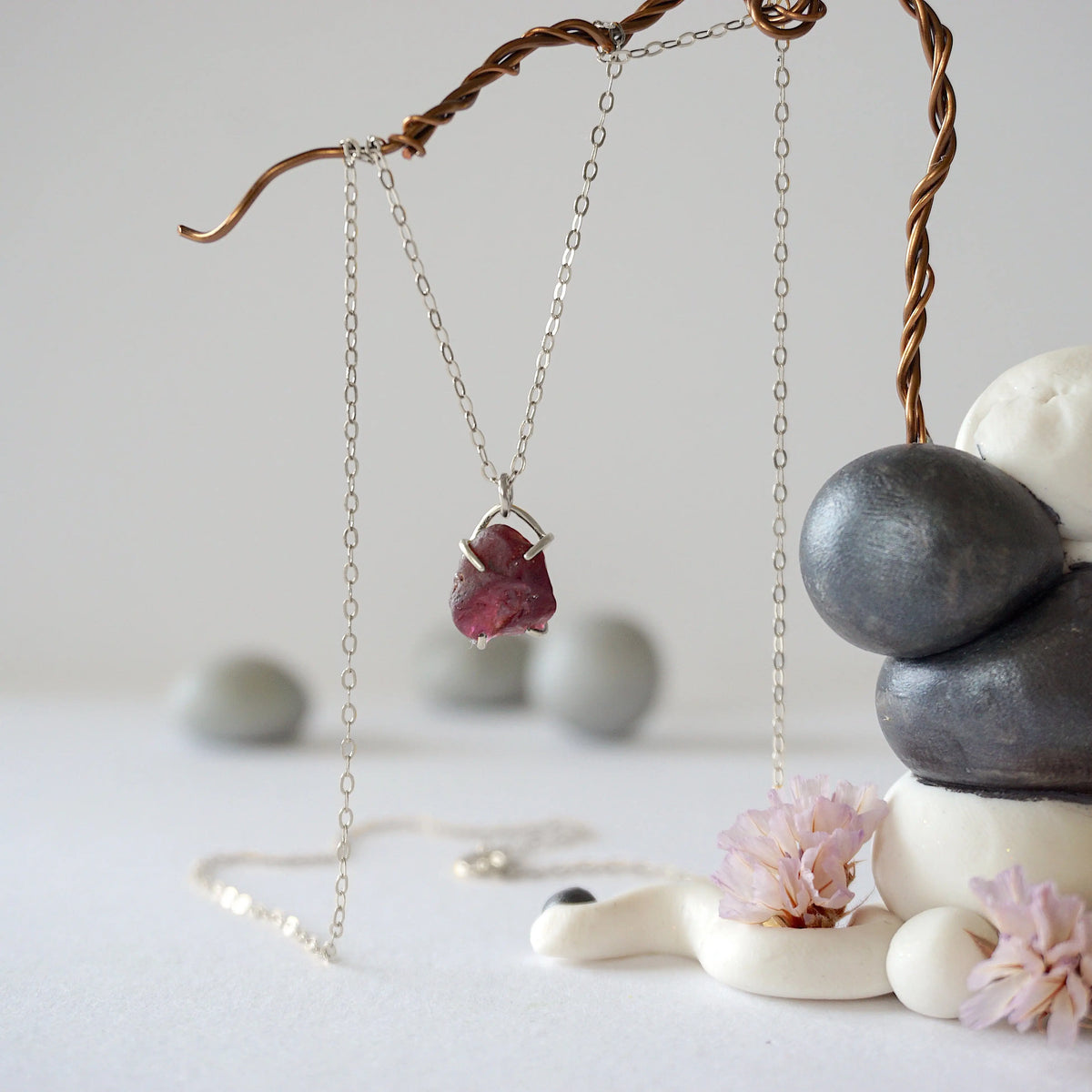 Full view of minimalist garnet necklace with raw garnet stone in 925 sterling silver claw setting on silver chain