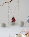 Back view of minimalist garnet pendant in sterling silver claw setting on a sterling silver chain