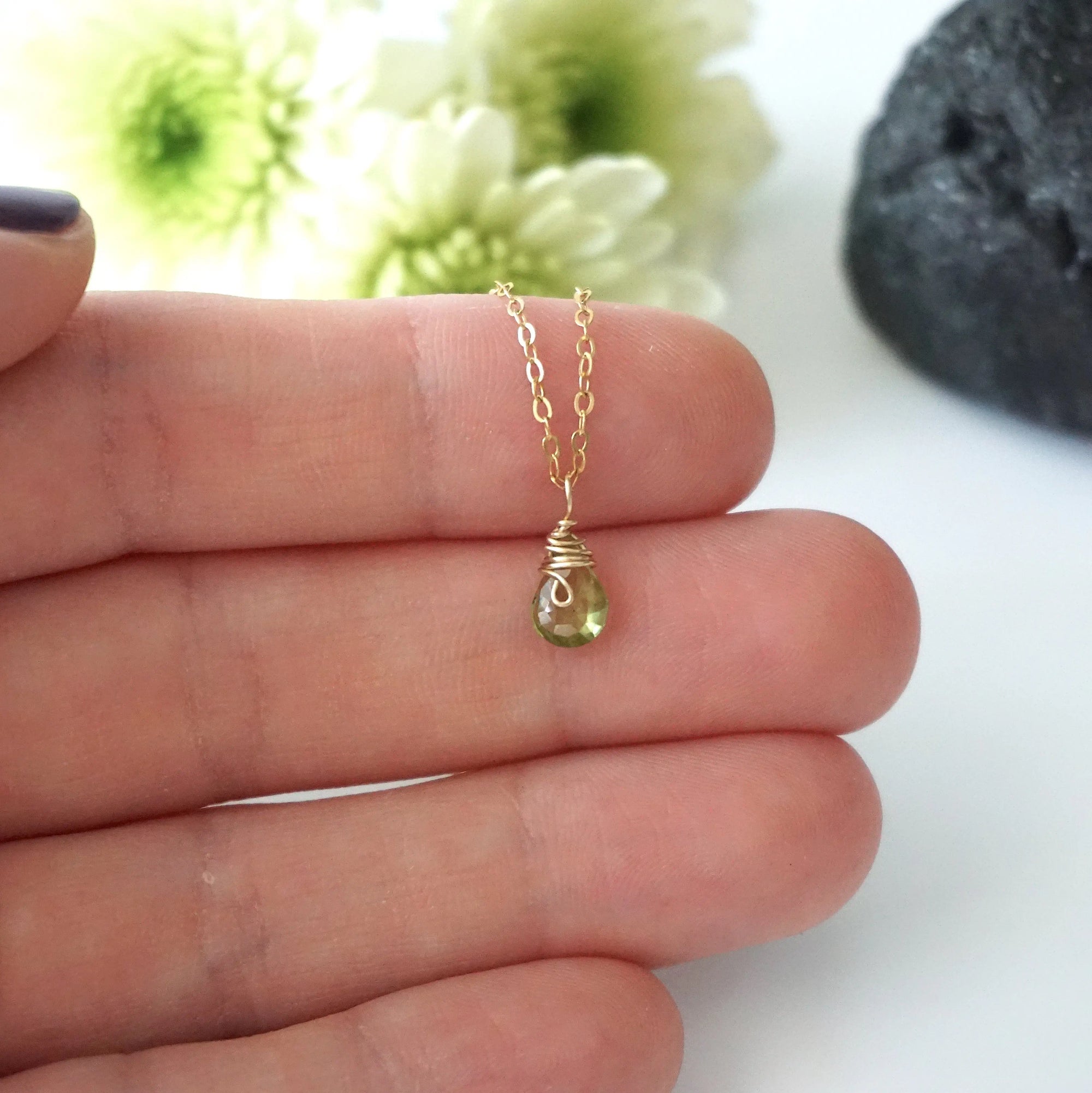 Dainty peridot necklace for women held in hand for size reference — faceted lime green peridot on 14k gold filled chain, minimalist August birthstone jewelry