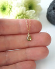 Dainty peridot necklace for women held in hand for size reference — faceted lime green peridot on 14k gold filled chain, minimalist August birthstone jewelry