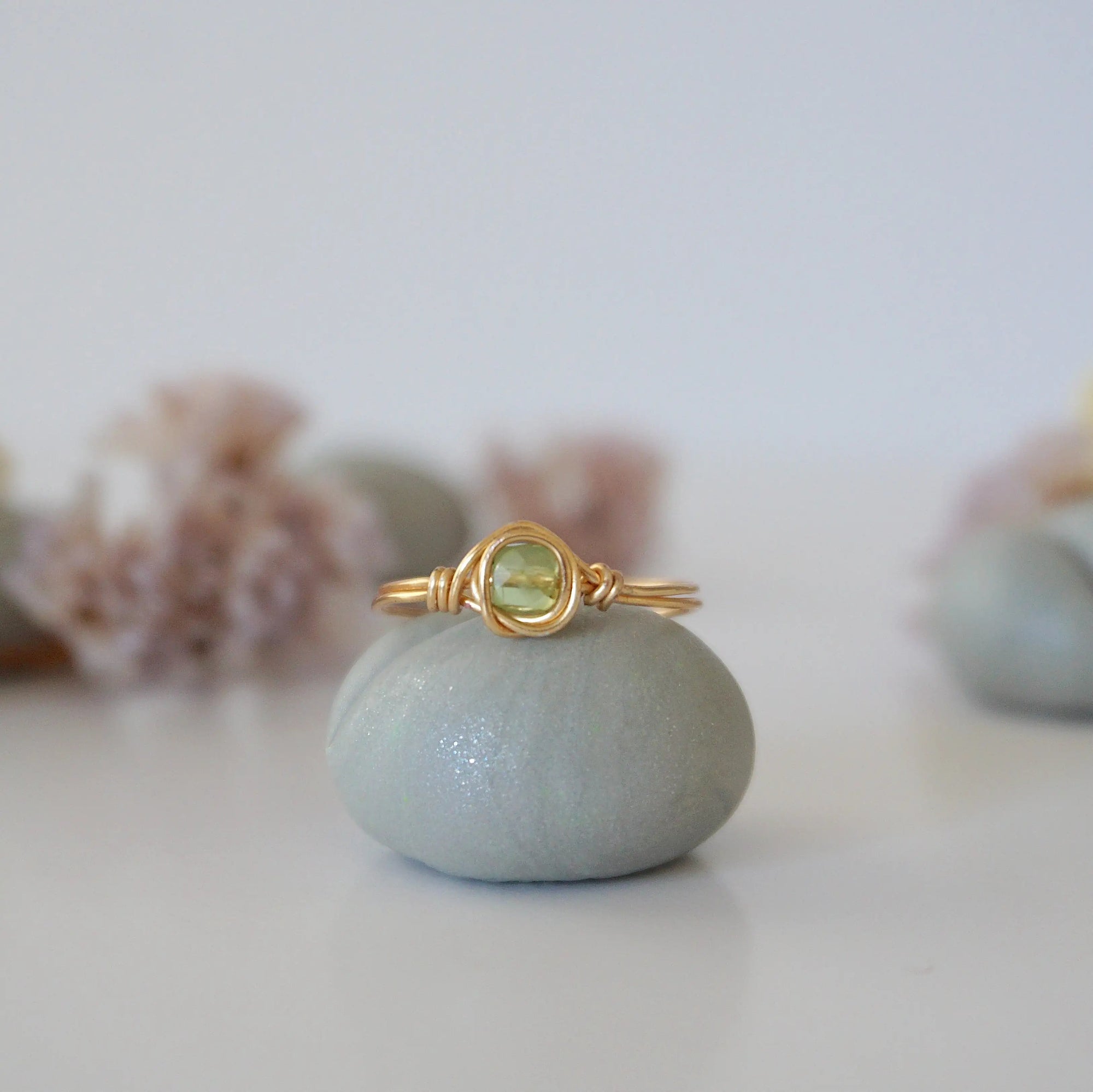 Front view of minimalist gold wire wrapped peridot ring — faceted 5mm olive green peridot bead in warm gold finish, dainty handcrafted August birthstone crystal ring for women