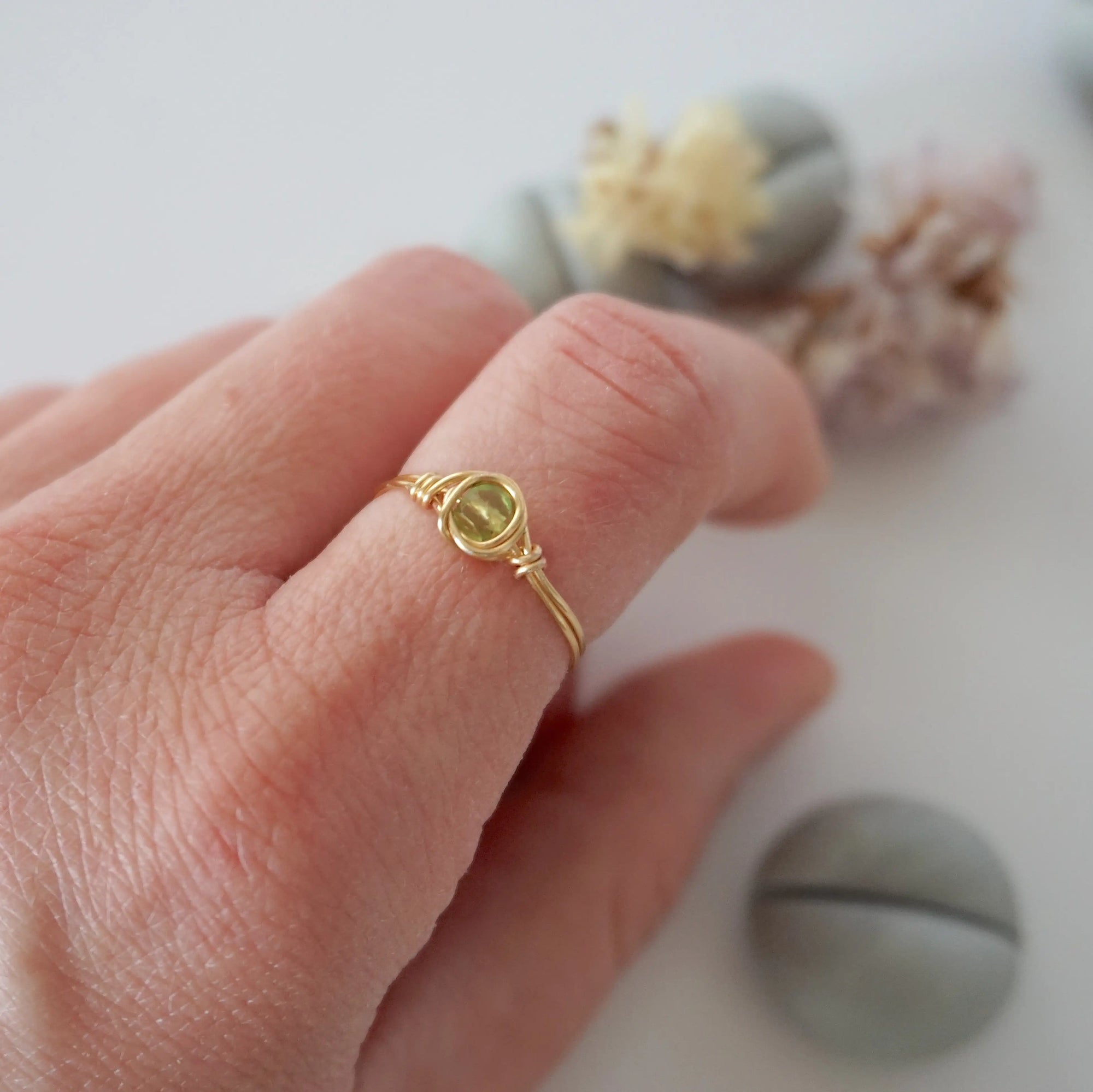 Minimalist peridot ring for women in gold finish — faceted olive green peridot bead wire wrapped on model's hand, dainty August birthstone crystal ring by Designs by Nature Gems
