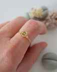 Minimalist peridot ring for women in gold finish — faceted olive green peridot bead wire wrapped on model's hand, dainty August birthstone crystal ring by Designs by Nature Gems