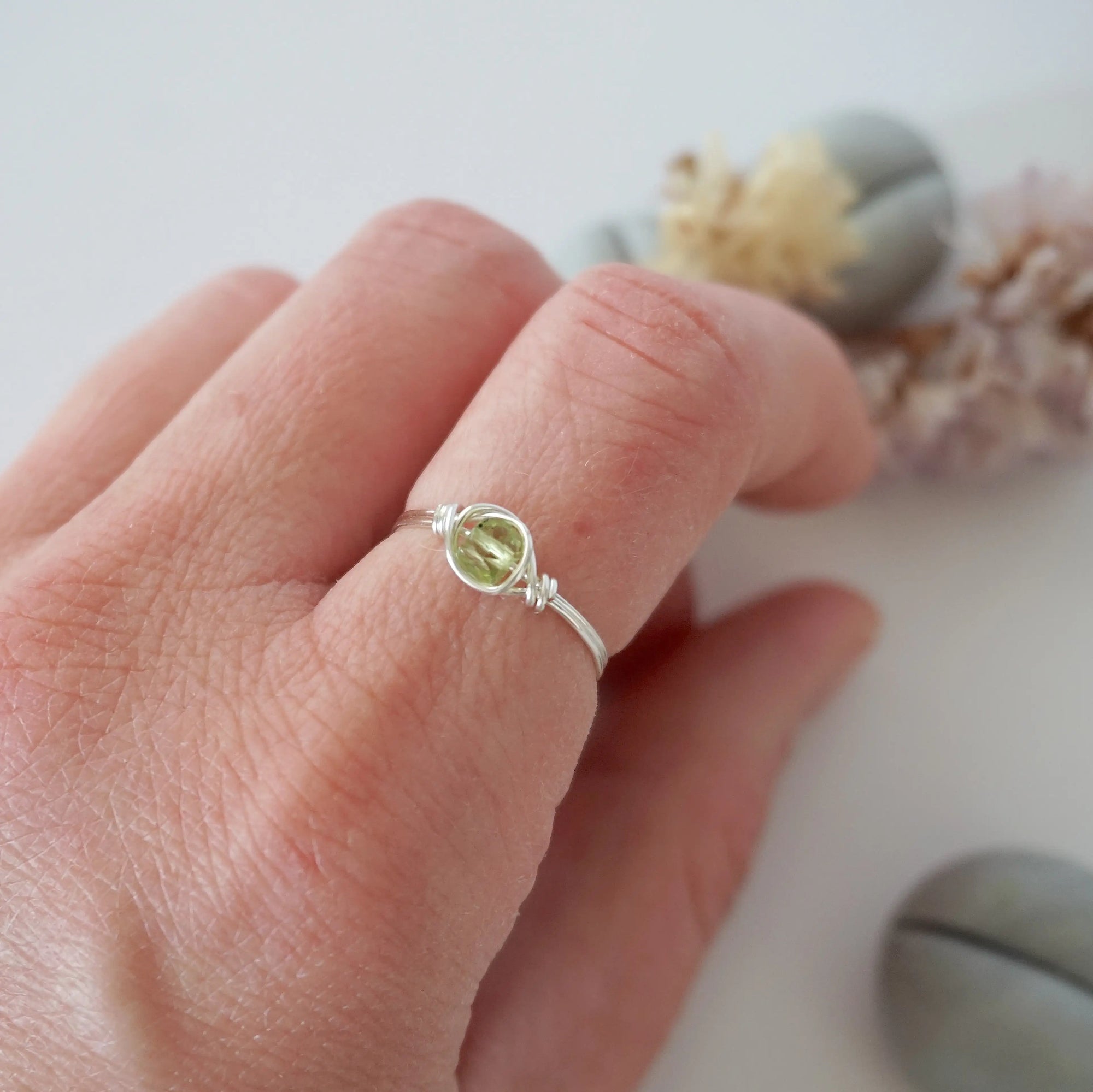 Minimalist peridot ring for women in silver finish — faceted olive green peridot bead wire wrapped on model's hand, dainty August birthstone crystal ring by Designs by Nature Gems