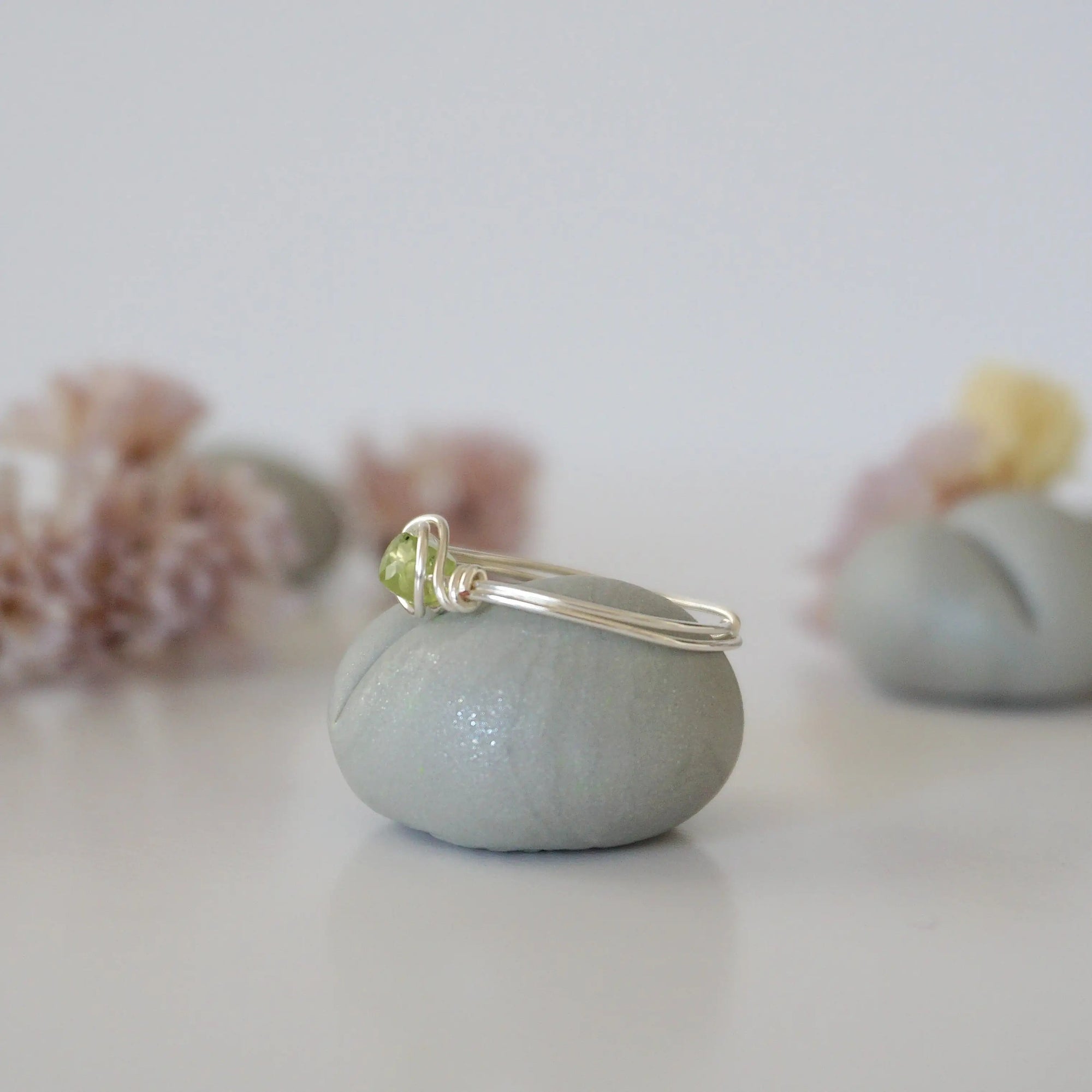 Side angle of minimalist silver wire wrapped peridot ring — artisan wire band and stone cradle detail, dainty August birthstone ring for women by Designs by Nature Gems