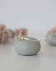 Side angle of minimalist silver wire wrapped peridot ring — artisan wire band and stone cradle detail, dainty August birthstone ring for women by Designs by Nature Gems