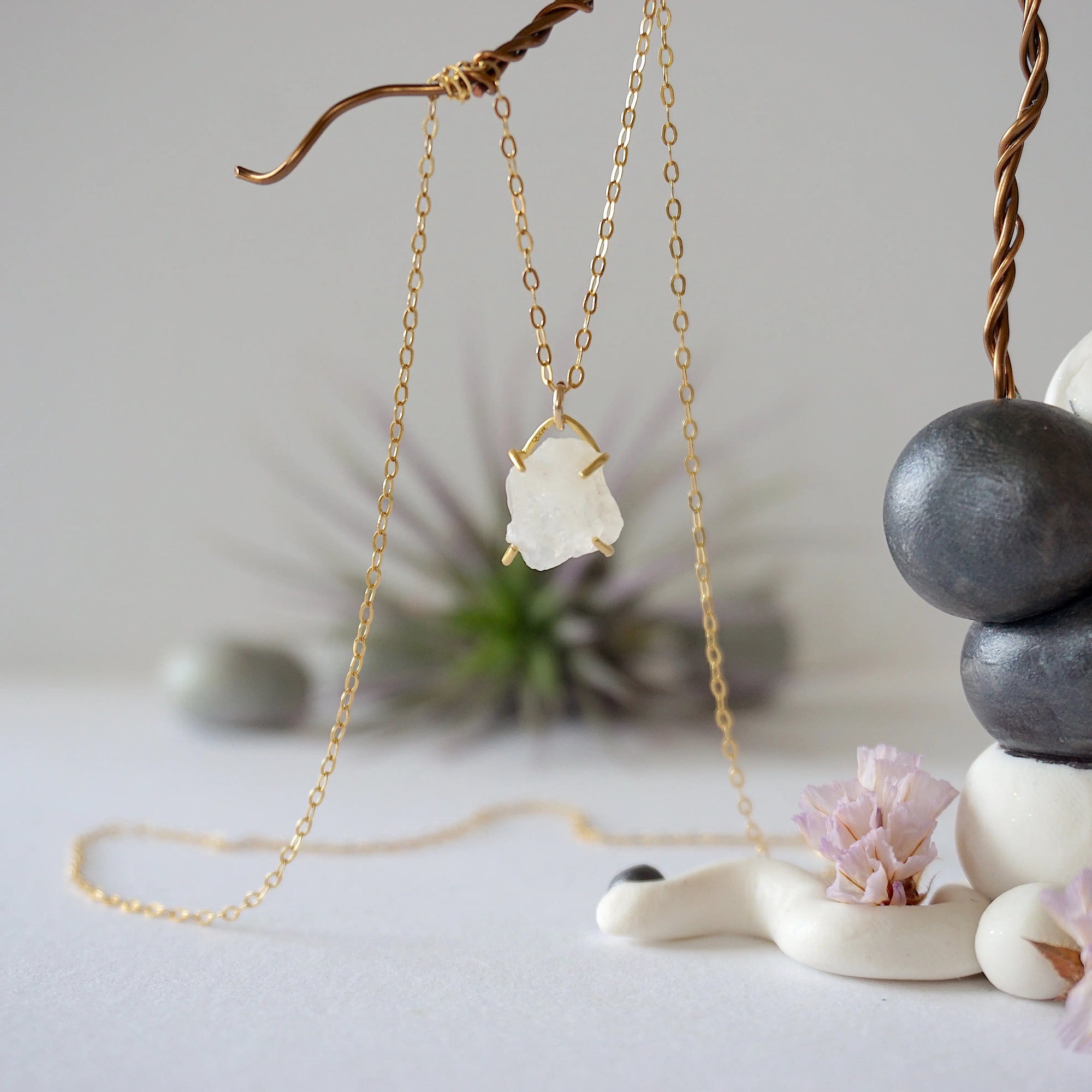 Close-up front view of minimalist rainbow moonstone necklace for women, natural raw moonstone in 14k gold vermeil prong setting on gold filled chain (June birthstone).