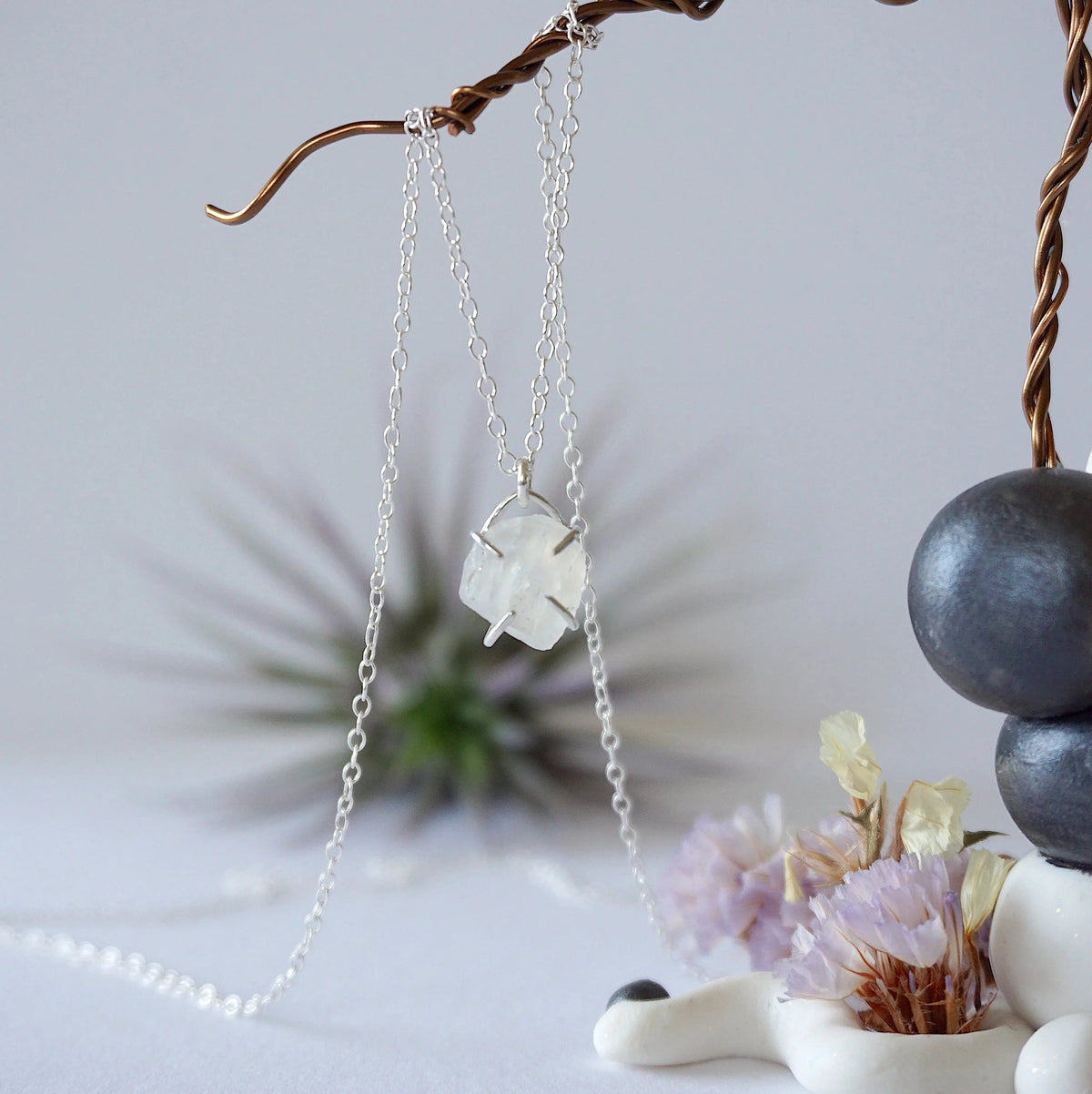 Close-up front view of minimalist rainbow moonstone necklace for women, natural raw moonstone in 925 sterling silver prong setting (June birthstone).