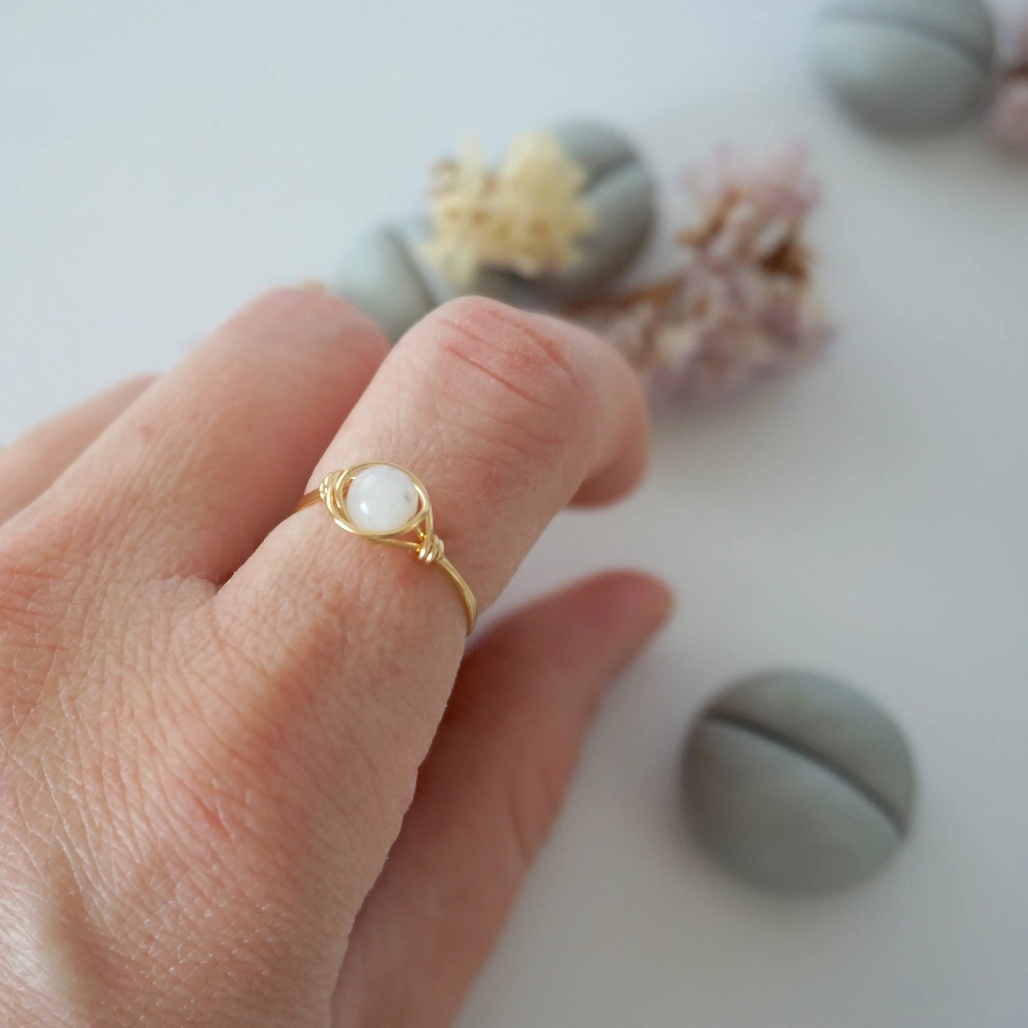 Minimalist rainbow moonstone ring for women in warm gold wire wrap on hand, dainty June birthstone ring.